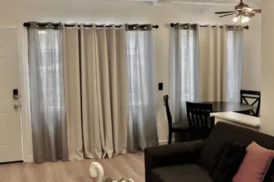 a living room with a couch and a table and curtains at Chic Apartment in Los Angeles