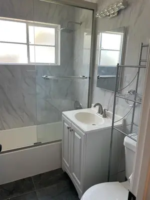 a bathroom with a shower and a sink and a toilet at Chic Apartment in Los Angeles