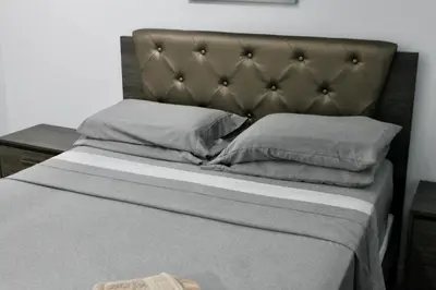 a bed with a brown headboard and two pillows at Chic Apartment in Los Angeles