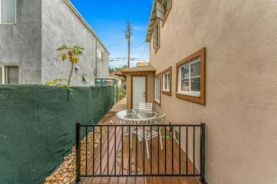 a balcony with a table and a fence next to a building at Charming Apartment in Santa Monica