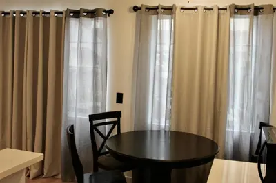 a table and chairs in a room with curtains at Charming Apartment in Santa Monica