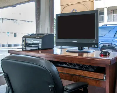 a desk with a computer monitor and a printer at Rodeway Inn Convention Center in Los Angeles