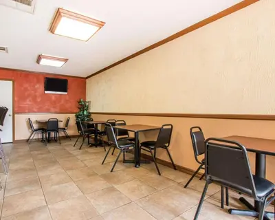 a conference room with tables and chairs and a wall at Rodeway Inn Convention Center in Los Angeles