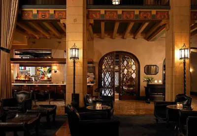 a lobby with chairs and tables and a bar at The Hollywood Roosevelt in Los Angeles