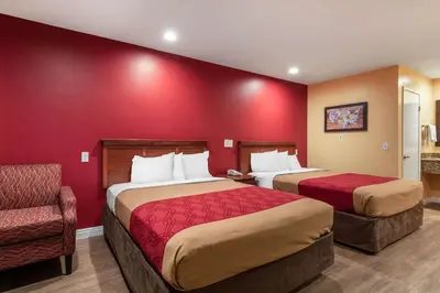 a hotel room with two beds and a chair at Rodeway Inn Carson - Los Angeles South in Carson