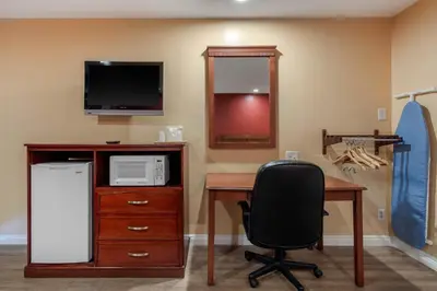 a room with a desk with a computer and a microwave at Rodeway Inn Carson - Los Angeles South in Carson