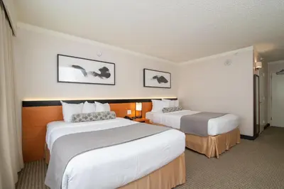 a hotel room with two beds and two pictures on the wall at Miyako Hotel Los Angeles in Los Angeles