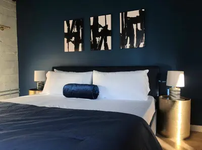 a bedroom with a bed with two pictures on the wall at THE MIDNIGHT LOFT BY BOBOU DESIGN (KING SUITE) in Los Angeles