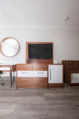 a living room with a flat screen tv on a wall at Pasadena Rose & Crown Hotel in Pasadena