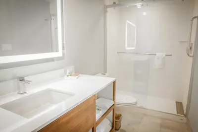 a white bathroom with a sink and a shower at Pasadena Rose & Crown Hotel in Pasadena