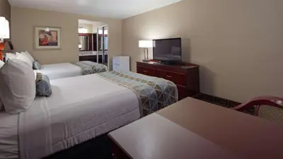 a hotel room with two beds and a flat screen tv at Best Western Pasadena Inn in Pasadena