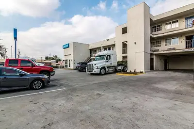 a truck parked in a parking lot in front of a building at Motel 6 Bell Gardens, CA - Los Angeles in Bell Gardens