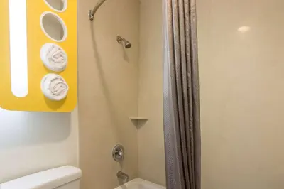 a bathroom with a shower and a toilet with towels at Motel 6 Bell Gardens, CA - Los Angeles in Bell Gardens