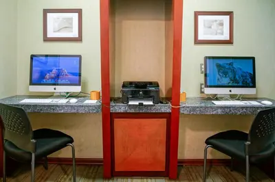 a room with two computer monitors and two chairs at Shade Hotel Manhattan Beach in Manhattan Beach