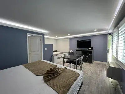 a bedroom with a bed and a desk and a television at Deluxe Inn Hawthorne/ LAX in Hawthorne
