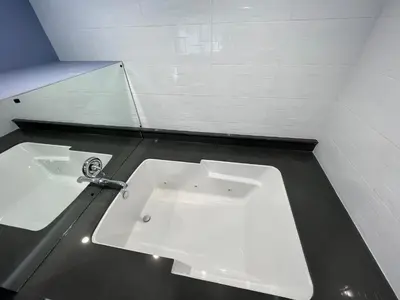 a bathroom with a white sink and a mirror at Deluxe Inn Hawthorne/ LAX in Hawthorne