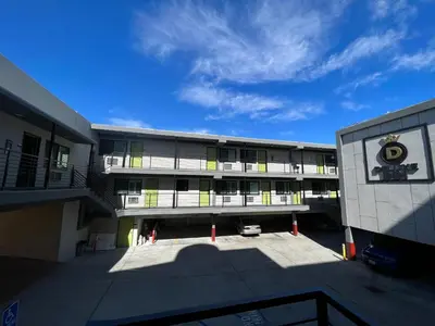 a large building with a parking lot in front of it at Deluxe Inn Hawthorne/ LAX in Hawthorne