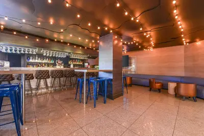 a bar in a restaurant with stools and lights at Quality Inn & Suites Montebello - Los Angeles in Montebello
