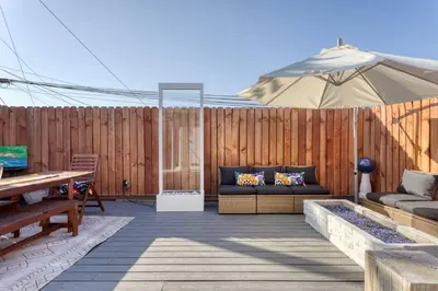 a patio with a couch and an umbrella at New Belmont Shore Retreat with free Parking Walk to Beaches in Long Beach
