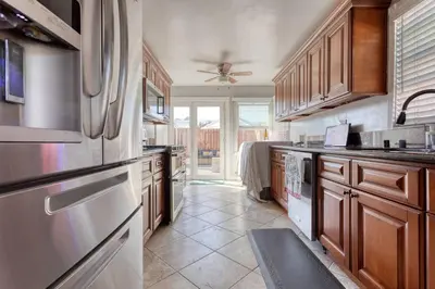a large kitchen with wooden cabinets and stainless steel appliances at New Belmont Shore Retreat with free Parking Walk to Beaches in Long Beach