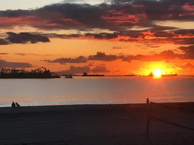 a sunset on the beach with the sun setting at New Belmont Shore Retreat with free Parking Walk to Beaches in Long Beach