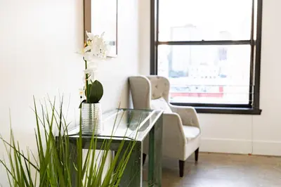 a living room with a glass table and a chair at Fashion Loft 2 bedroom Downtown in Los Angeles