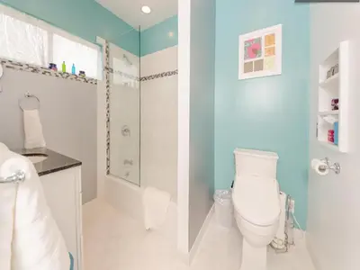 a bathroom with a white toilet and a blue wall at Venice Beach Apartments Monthly rents in Los Angeles