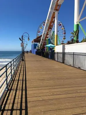 a boardwalk with a roller coaster on the beach at Venice Beach Apartments Monthly rents in Los Angeles