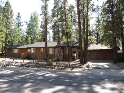 a log cabin in the woods with trees at Monticello in Big Bear Lake