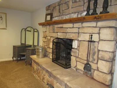 a stone fireplace in a living room at Monticello in Big Bear Lake