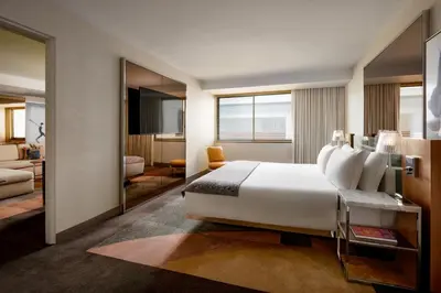 a bedroom with a large white bed and a living room at SLS Hotel, a Luxury Collection Hotel, Beverly Hills in Los Angeles