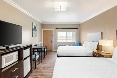 a hotel room with two beds and a flat screen tv at Best Western China Lake Inn in Ridgecrest