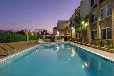 a swimming pool in a apartment complex at night at Best Western Plus South Bay Hotel in Lawndale