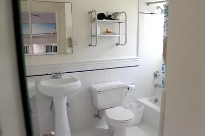 a white bathroom with a toilet and a sink at Bayside Hotel in Los Angeles
