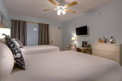 a hotel room with two beds and a ceiling fan at Bayside Hotel in Los Angeles