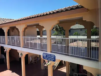 a building with a balcony with a blue sign on it at Starlight Inn Canoga Park in Canoga Park