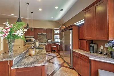 a kitchen with wooden cabinets and a vase of flowers at Roomy Home with Deck, 5 Mi to Lake Arrowhead Village in Lake Arrowhead