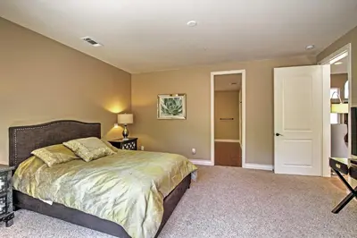 a bedroom with a large bed and a hallway at Roomy Home with Deck, 5 Mi to Lake Arrowhead Village in Lake Arrowhead