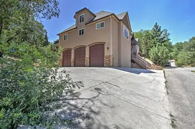 a house with two garage doors on a driveway at Roomy Home with Deck, 5 Mi to Lake Arrowhead Village in Lake Arrowhead