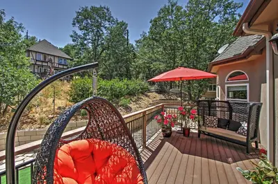a porch with a bench and an umbrella at Roomy Home with Deck, 5 Mi to Lake Arrowhead Village in Lake Arrowhead