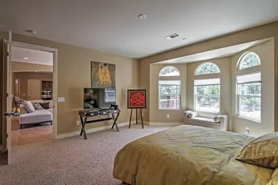 a bedroom with a bed and a living room at Roomy Home with Deck, 5 Mi to Lake Arrowhead Village in Lake Arrowhead