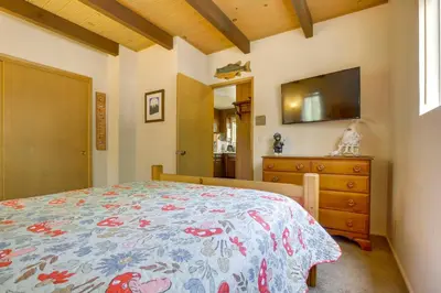 a bedroom with a bed and a dresser and a television at Lake Arrowhead Family Home with Game Room in Lake Arrowhead