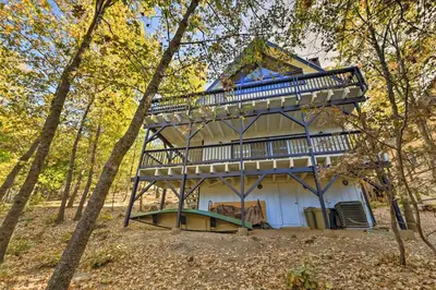a house with a large deck in the woods at Lake Arrowhead Family Home with Game Room in Lake Arrowhead