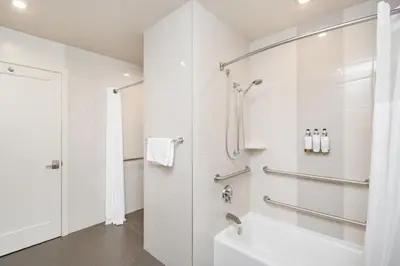 a white bathroom with a shower and a sink at Aiden Los Angeles Downtown Dragon Gate Inn in Los Angeles