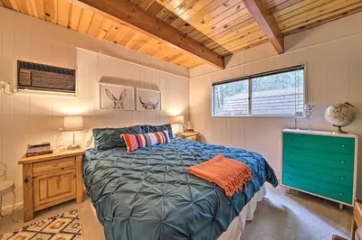a bedroom with a bed and a desk and a window at Lake Arrowhead A-Frame House with Private Hot Tub! in Lake Arrowhead