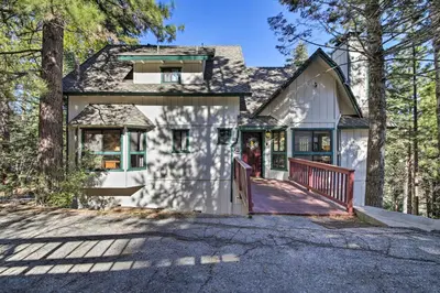 a white house with a porch in the woods at Spacious Lake Arrowhead Home with 2 Decks and Views in Lake Arrowhead
