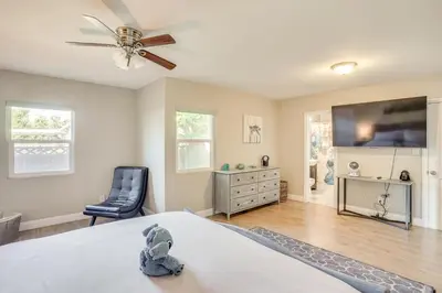 a bedroom with a bed with a ceiling fan and a tv at Fullerton Vacation Rental with Private Pool! in Fullerton