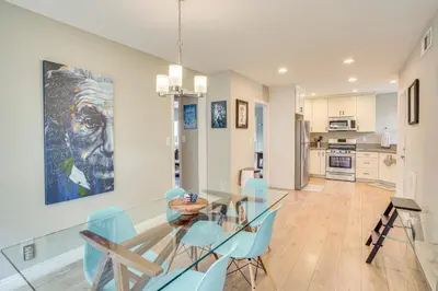 a dining room with a glass table and blue chairs at Fullerton Vacation Rental with Private Pool! in Fullerton