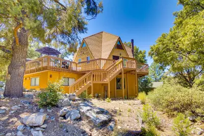 a large yellow house with a large deck at Star House Unique Home with 360 Mountain Views! in Pine Mountain Club