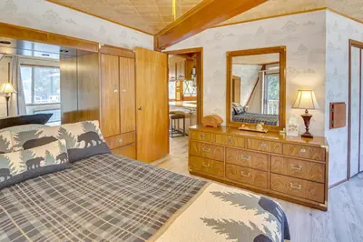 a bedroom with a bed and a dresser with a mirror at Star House Unique Home with 360 Mountain Views! in Pine Mountain Club